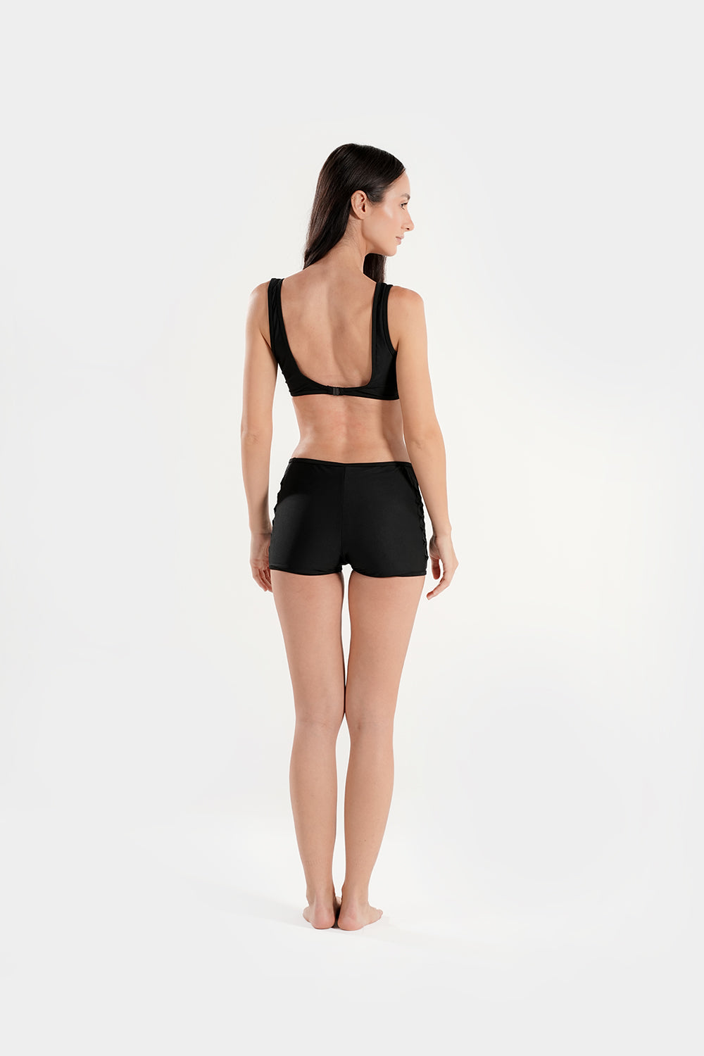 Women’s high-waisted bikini set by BAE Modest with lattice mesh detail and sporty shorts, shown on a model in a beach setting.
