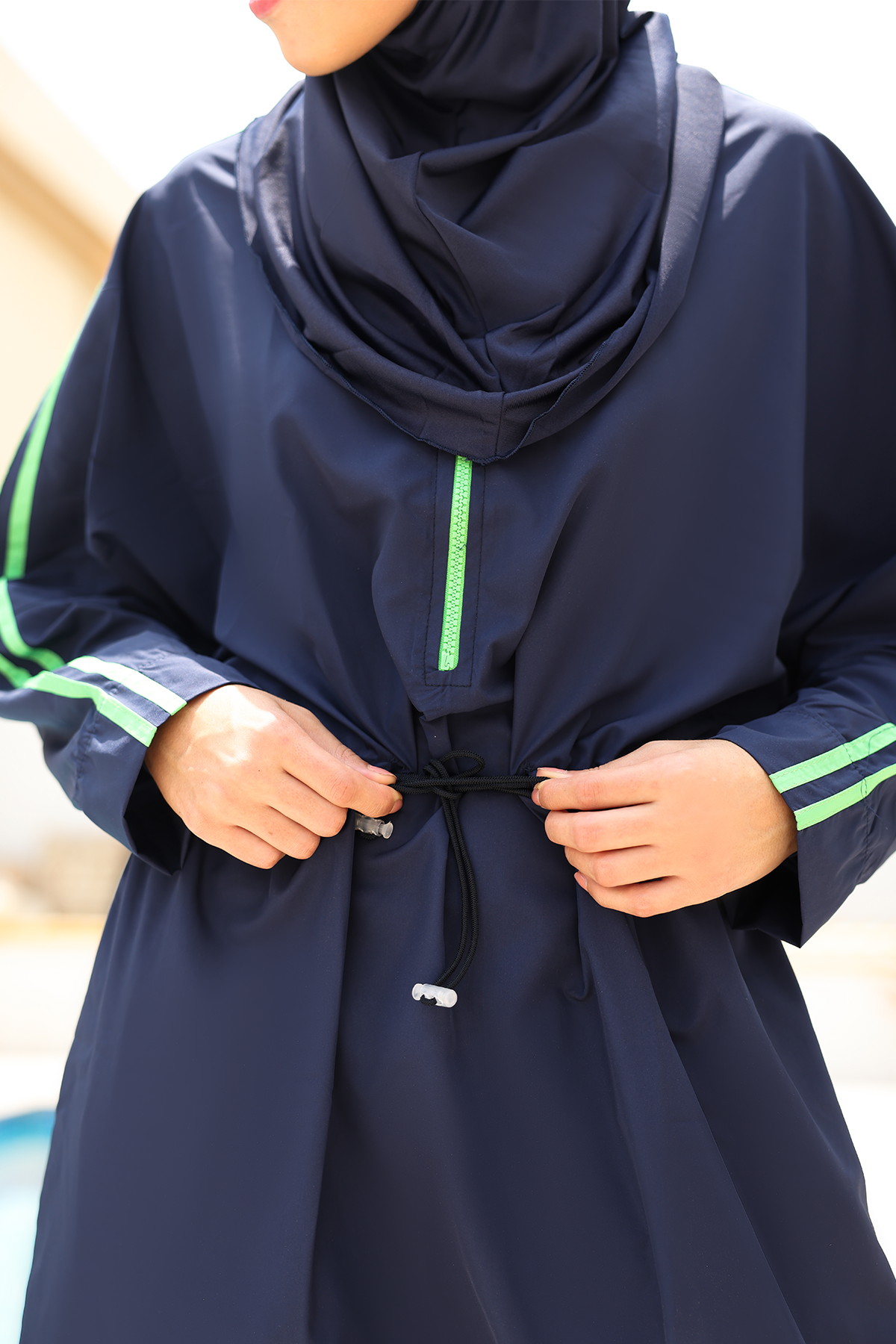 Navy blue Burkini with green accents on a blurred background